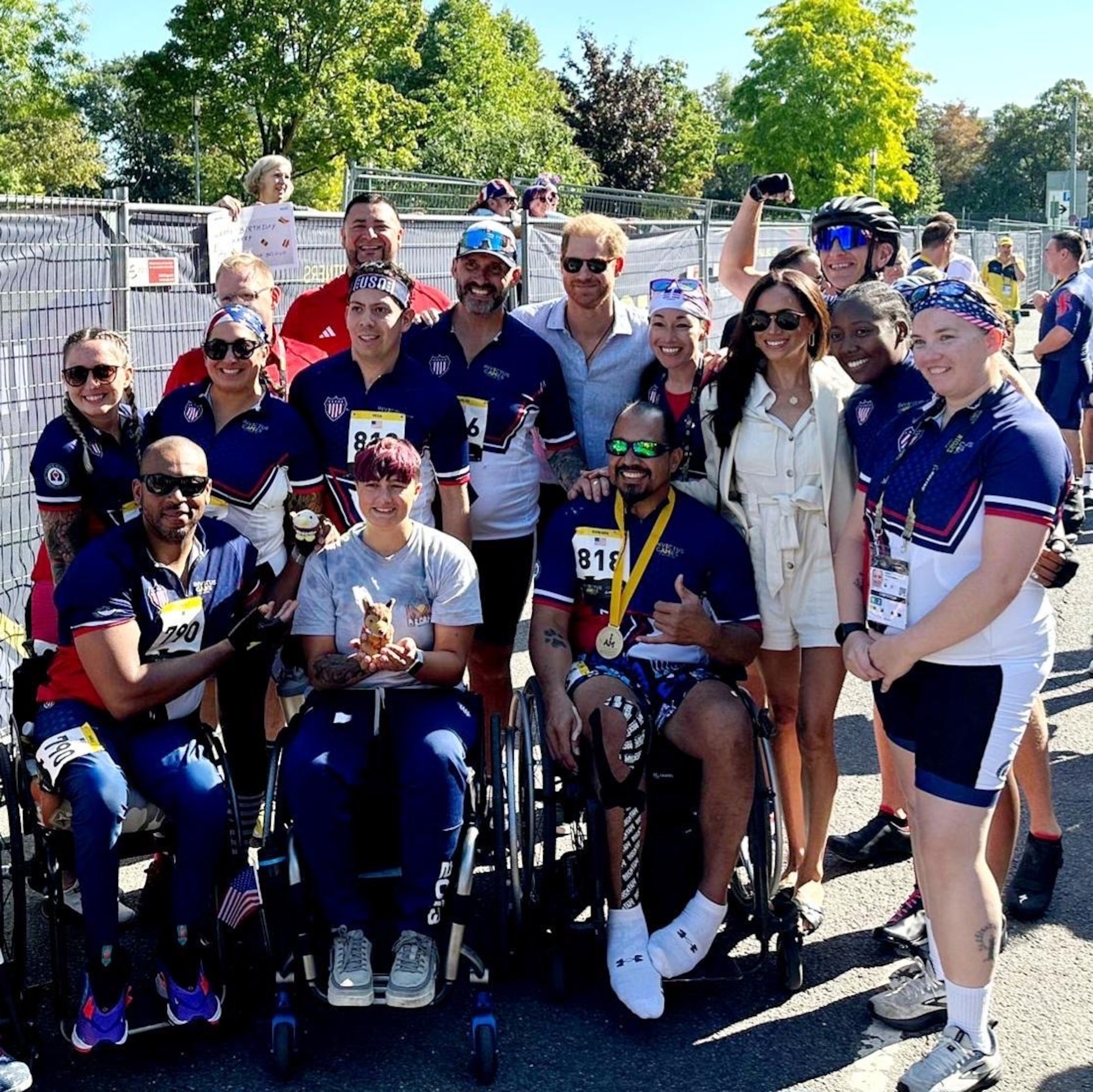 U.S. Air Force Senior Master Sgt. Nicole Favuzza, 70th Operations Support Squadron senior enlisted leader, stands between Prince Harry, center, Duke of Sussex, and Meghan Markle, Duchess of Sussex, during the Invictus Games Düsseldorf 2023, Sept. 15, in Germany. The games welcomed around 500 competitors from 21 nations and believes in empowering individuals to reclaim their sense of purpose, identity, and future, transcending the boundaries of their injuries. In 2018, Favuzza was diagnosed with Adenoid Cystic Carcinoma, a rare and incurable form of cancer. (Courtesy photo)