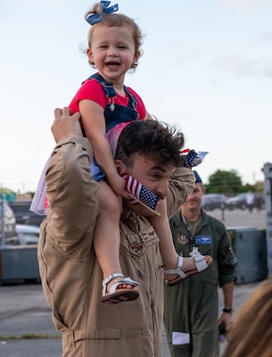 Soldier carrying a small girl on his shoulders.
