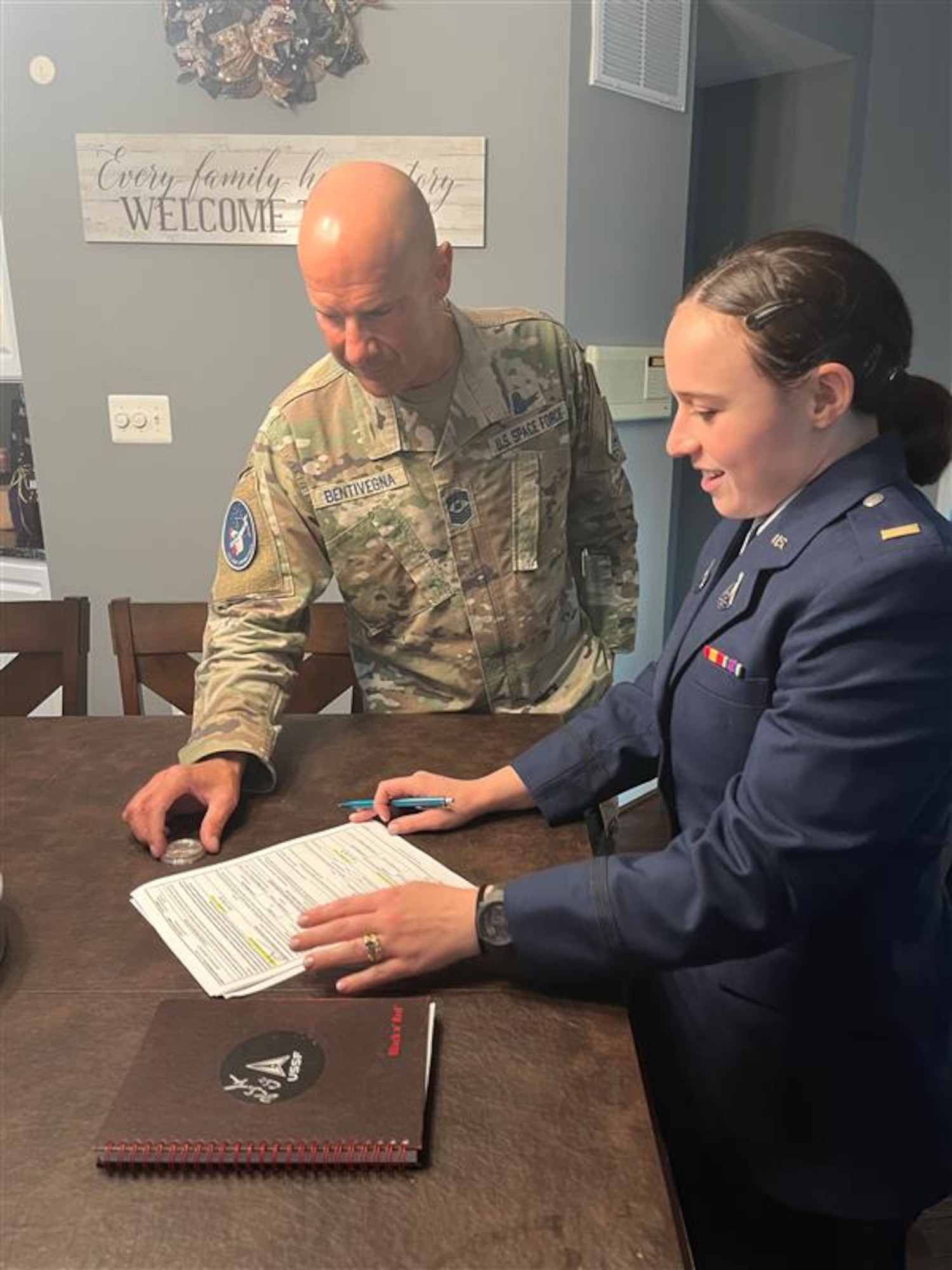 U.S. Space Force 2nd Lt. Josephine Lerner signs the reenlistment papers for Chief Master Sgt. of the Space Force John F. Bentivegna before administering the oath of office during his Reenlistment Ceremony on August 19, 2023, in Manassas, Virginia