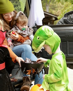 Dinosaur 3-year-old Dorian Stech picks out some candy at the trunk manned by 9-month-old Olivia Dosier and her mother, Casi Legler during the Illinois National Guard Family Programs "Trunk or Treat" on Oct. 28 on Camp Lincoln in Springfield, Illinois. The Illinois National Guard is also holding a Trunk or Treat for military families on Sunday, Oct. 29, 1-4 p.m., at the North Riverside Armory, 8660 W. Cermak Road, North Riverside, Illinois. The Trunk or Treat is a family and pet-friendly event open to servicemembers, veterans and their families throughout Chicagoland area. There will be costume contests with prizes for adults, children, and pets.