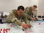 U.S. Army Spc. Jose Romero, advanced field artillery tactical data system operator, 169th Field Artillery Brigade, Colorado Army National Guard, plots target data for fire missions to monitor trends on a simulated battlefield during the brigade’s communication exercise at Camp Guernsey, Wyoming, Sept. 14, 2023. Exercise injects, such as the one Romero is plotting, are part of the train-up to the brigade’s mobilization validation.