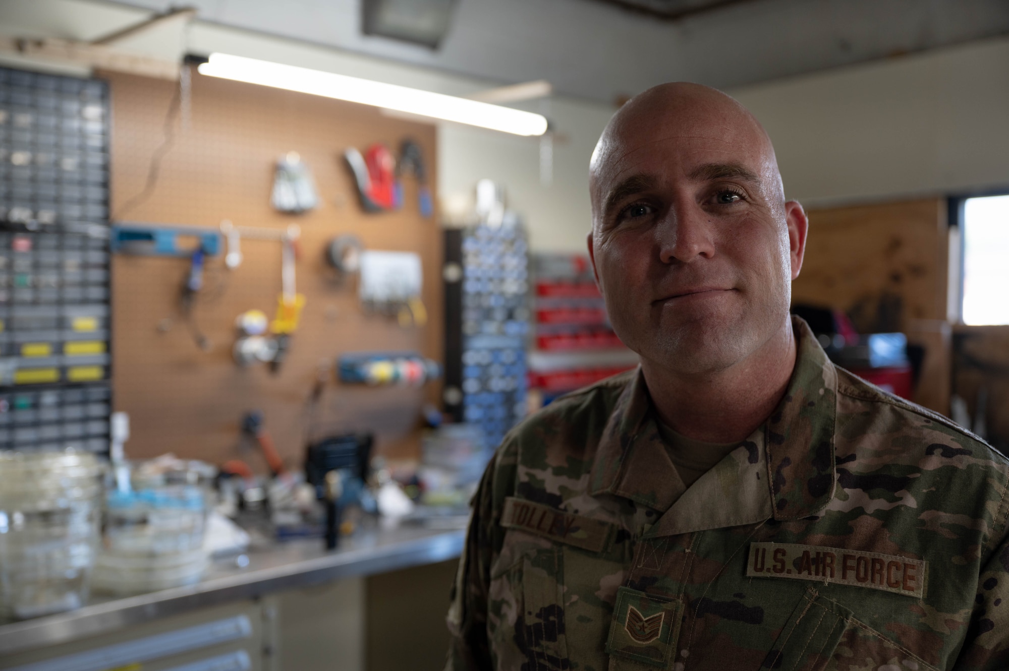U.S. Air Force Tech. Sgt. Christopher Tolley, explosive ordnance disposal technician from the 87th Civil Engineer Squadron, stands in front of an EOD workshop on Joint Base McGuire-Dix-Lakehurst, N.J., Oct. 10, 2023. The 87th CES/EOD implemented 3D printed training ordnance to rapidly adapt to new threats entering the battle space and more accurately simulate activation feedback from the device.