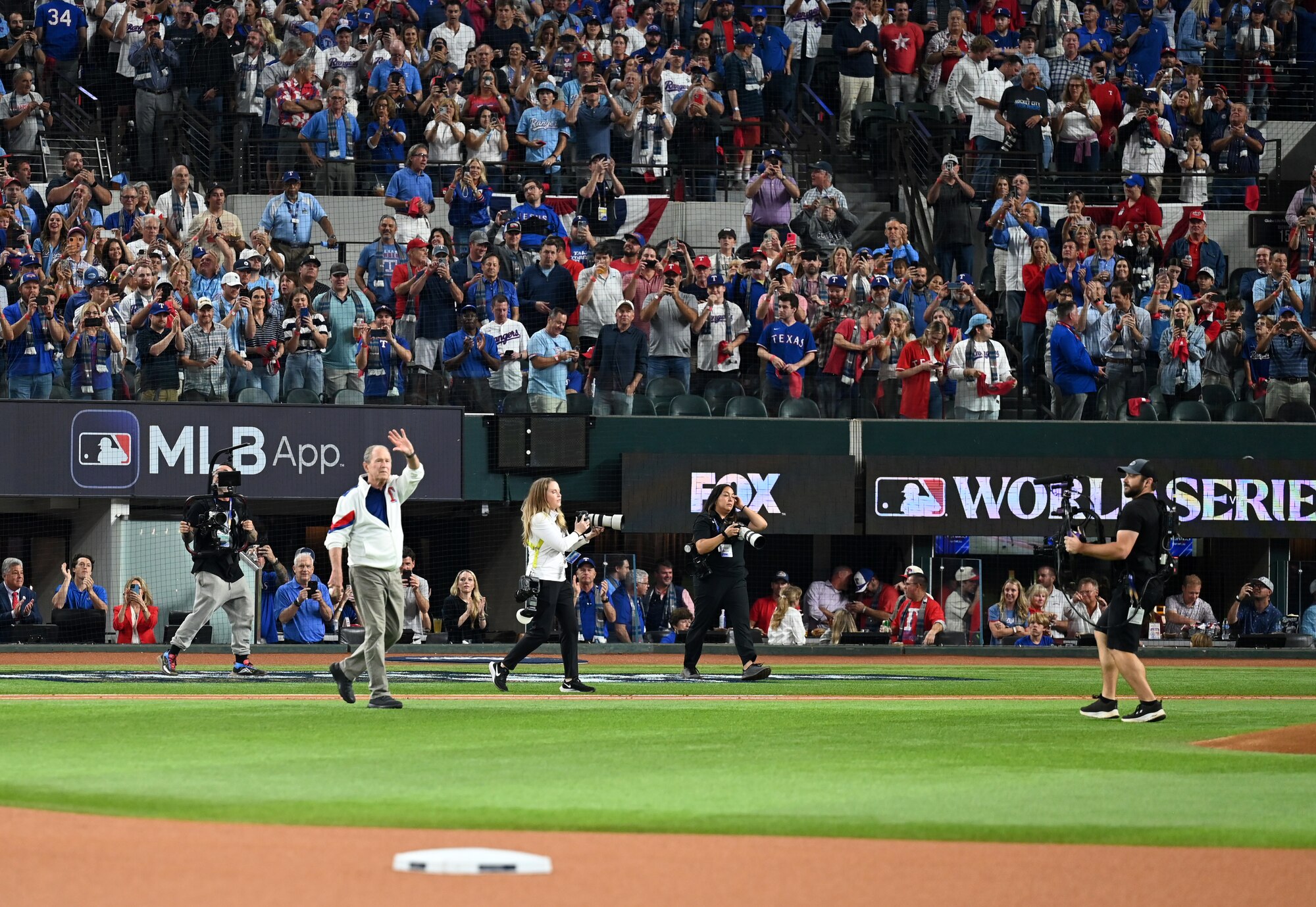 Former President George W. Bush greets the crowd during the pre-game ceremony at the World Series opening game at Globe Life Field in Arlington, Texas, Oct. 27, 2023. Bush has played a pivotal role within the Texas Rangers franchise including being a partial owner for more than 10 years and participating in pre-game festivities. (U.S. Air Force photo by Staff Sgt. Holly Cook)