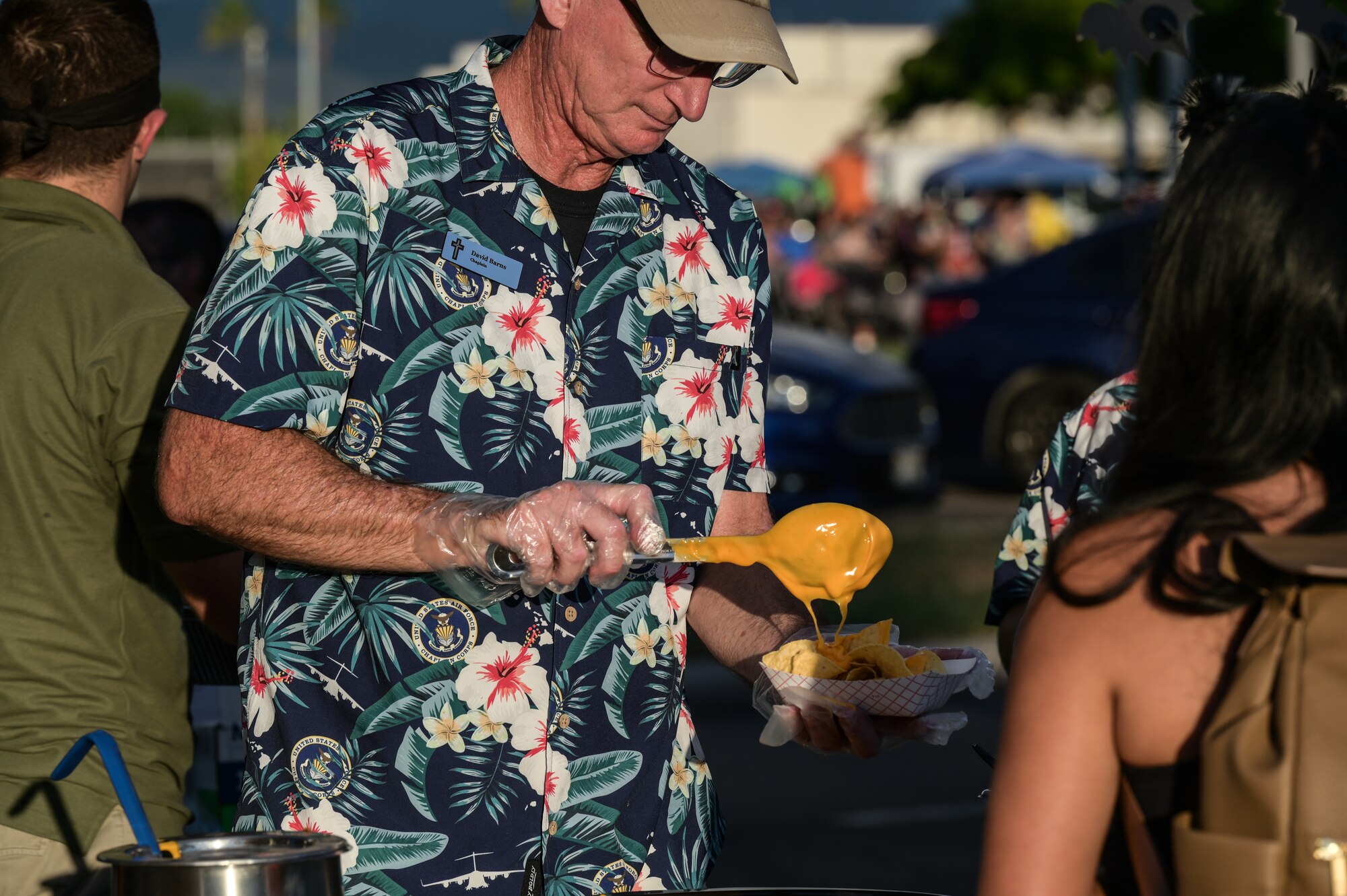 Lt. Col. David Barnes, 647th Air Base Group chaplain, serves food to trick-or-treaters during a 15th Wing Trunk-or-Treat event at Joint Base Pearl Harbor-Hickam, Hawaii, Oct. 27, 2023. The event was hosted by the Hickam Sexual Assault Prevention and Response office and chapel, providing a safe and fun way for children of the military and civilian employees to trick-or-treat. (U.S. Air Force photo by Staff Sgt. Alan Ricker)