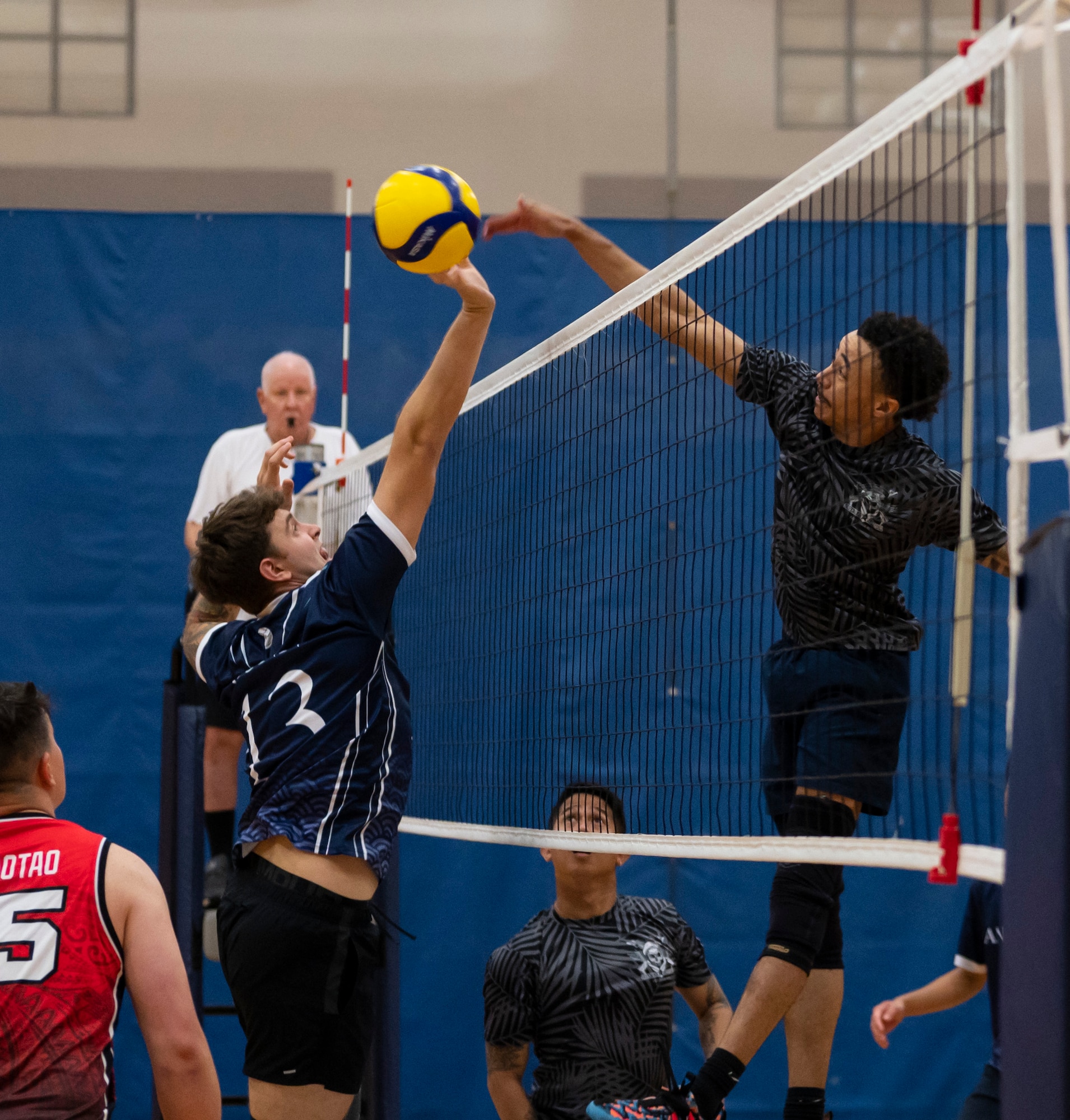 U.S. Air Force Senior Airman Jeremiah Watts, a member of the Security Forces Squadron’s intramural volleyball team hits the ball while U.S. Air Force Senior Airman Archie Conn, a member of the Civil Engineer Squadron’s intermural volleyball team, defends it during the championship game on Andersen Air Force Base, Guam, Oct. 26, 2023.  Andersen’s intramural volleyball league ended in a climactic final game between the Security Forces Squadron and CES. The game ended with SFS being named the champions. (U.S. Air Force photo by Airman 1st Class Spencer Perkins)