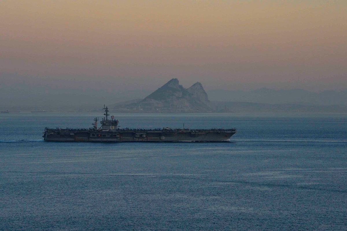 A military ship navigates in a body of water.