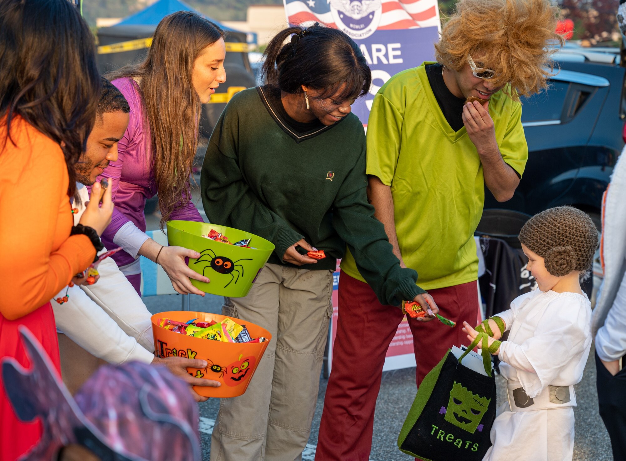 Trunk-or-Treat volunteers give candy to a military child at Osan Air Base, Republic of Korea, Oct. 27, 2023. The event created a safe environment for military members and their families to celebrate Halloween with candy and entertainment to enable community connectiveness. (U.S. Air Force photo by Staff Sgt. Kelsea Caballero)