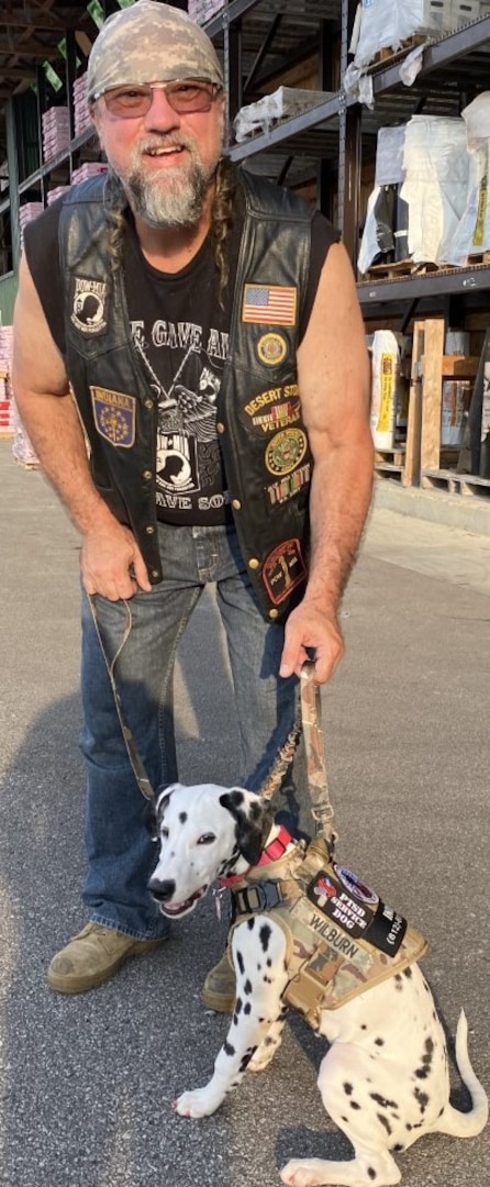 A man stands with his service dog.