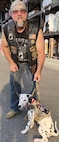 A man stands with his service dog.
