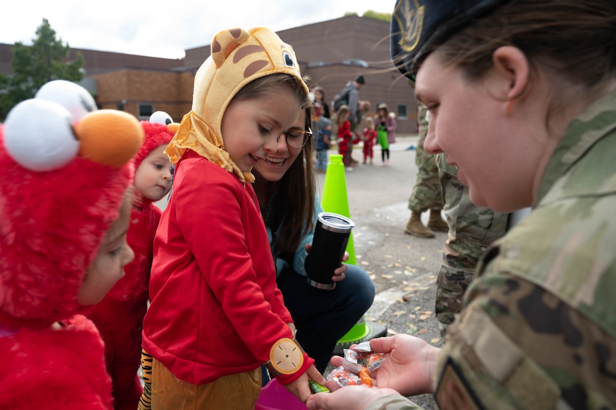 Families of 934th Airlift Wing service members collect candy from security forces personnel during a "Trunk or Treat" event on Oct. 14, 2022 at Minneapolis-St. Paul Air Reserve Station, Minnesota. The event was designed to help build relationships between Airmen's families and the 934 AW. (U.S. Air Force photo by Senior Airman Victoriya Tarakanova)