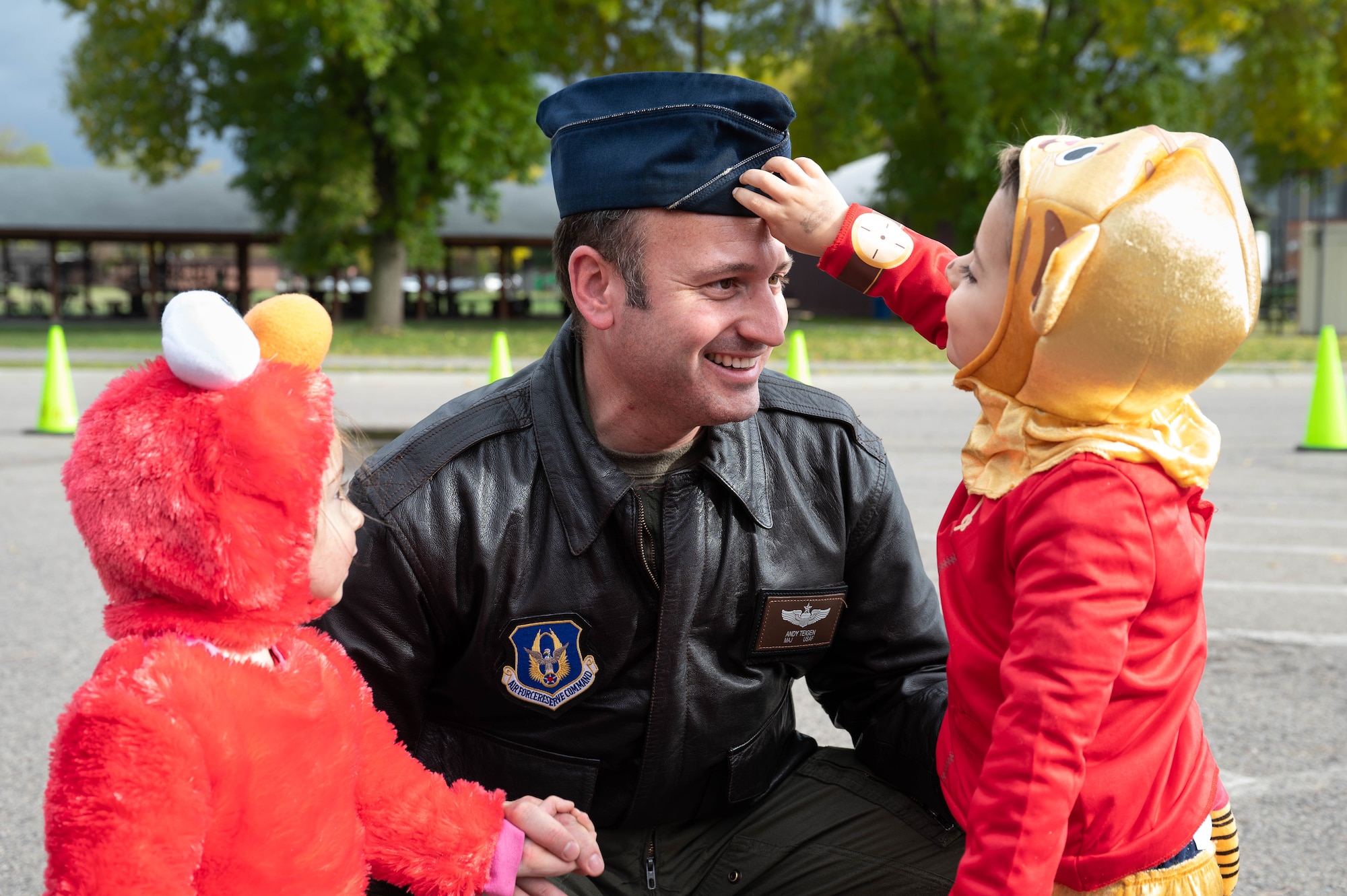 Major Andy Teigen, 96th Airlift Squadron pilot, spends time with his children during a "Trunk or Treat" event on Oct. 14, 2022 at Minneapolis-St. Paul Air Reserve Station, Minnesota. The event was organized by the 934th Airlift Wing Military Family Readiness program, which helps support service member families. (U.S. Air Force photo by Senior Airman Victoriya Tarakanova)