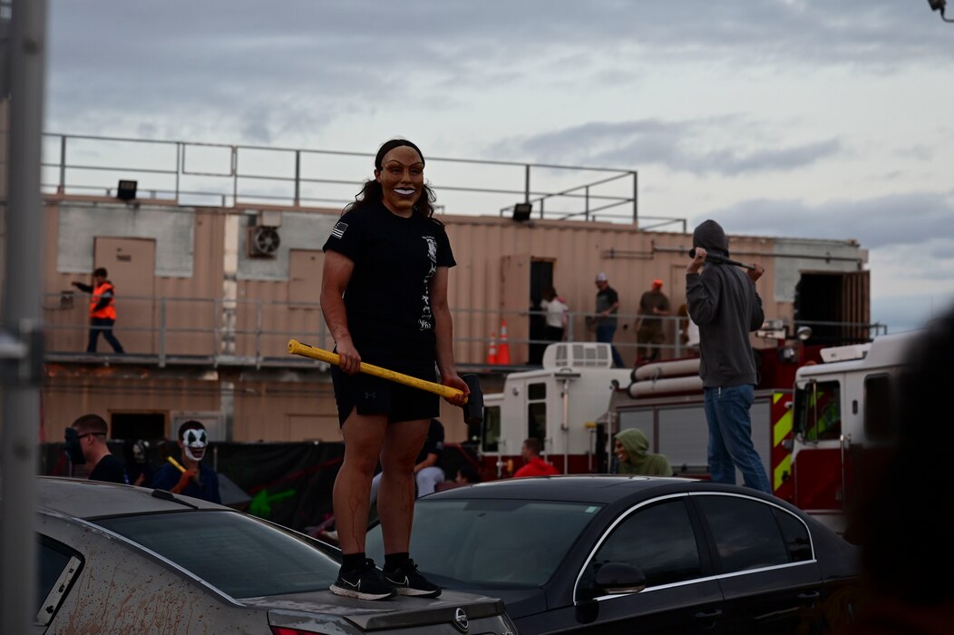 Volunteers who dressed as scare actors participating in the 312th Training Squadron haunted house, prepare their props and rehearse during the Ghoulfellow Trunk or Treat event hosted at the Louis F. Garland Fire Academy, Goodfellow Air Force Base, Texas, Oct. 28, 2023. After the trunk or treat, families could enjoy a haunted house suitable for their children hosted by the 312th Training Squadron. (U.S. Air Force photo by Airman 1st Class Madison Collier)