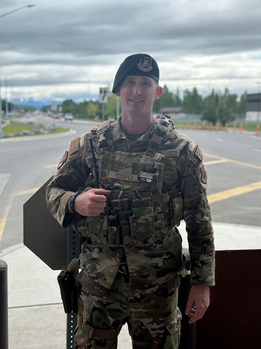 Image of Senior Airman Justin Cooper in his Security Forces uniform with trees in the background in Alaska, June 2023.