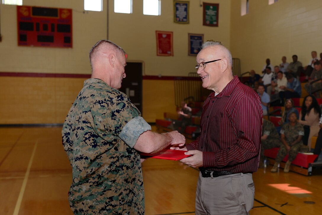 Maj. Gen Maxwell shaking hands with a man inside a gymnasium.