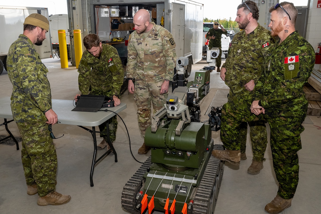 A group of military members from both Canada and the U.S. test a robotic device.