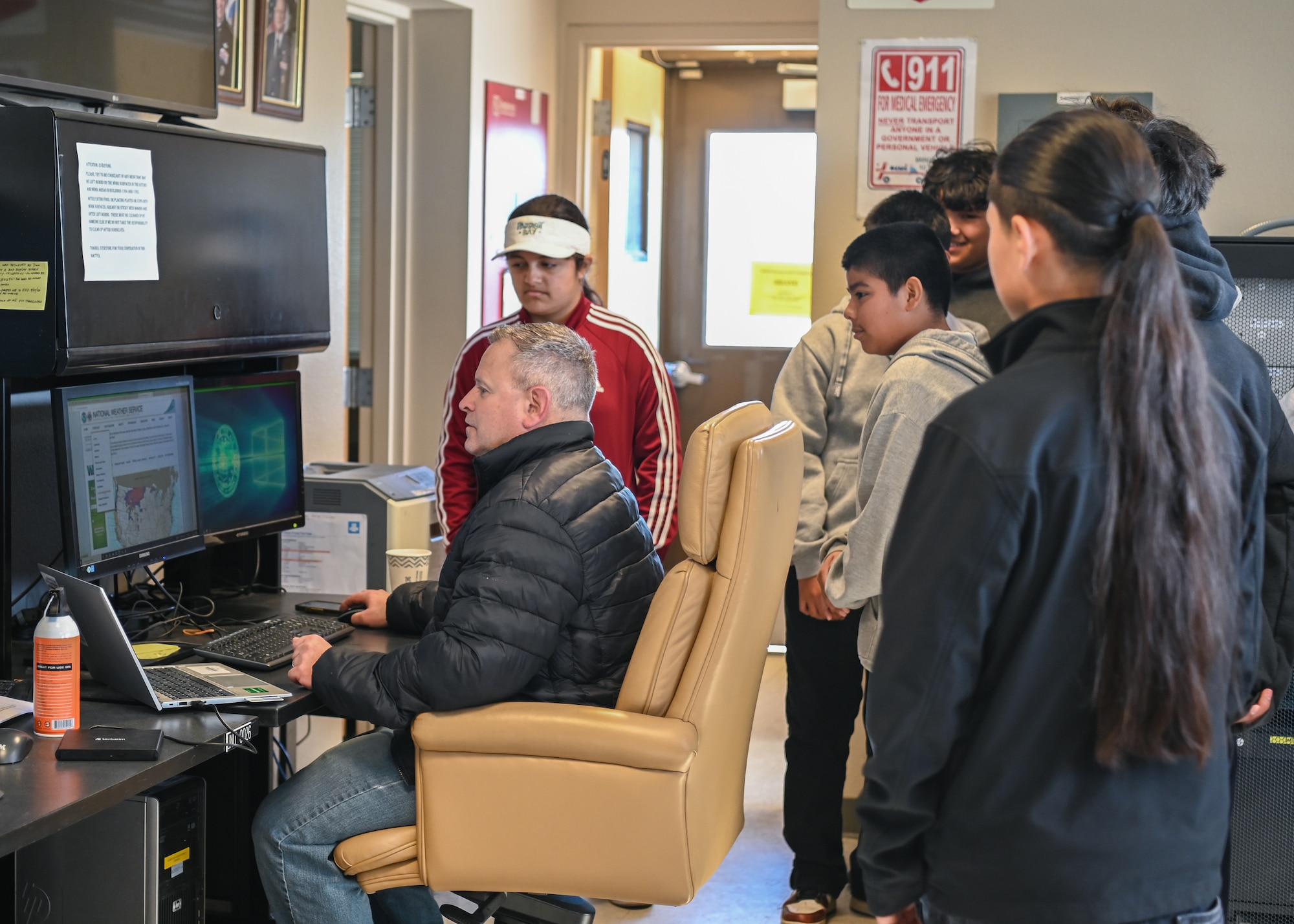 A weather observer shows eighth grade students from Kermit McKenzie Intermediate School how they track weather balloons after they are released.