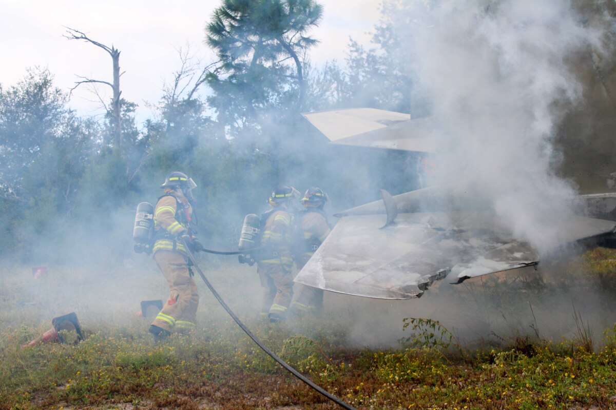Firefighters from the Royal Canadian Armed Forces join the 801st Red Horse squadron for a hand line operation exercise