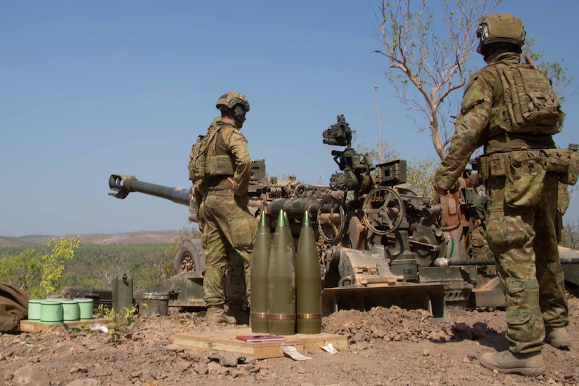 Foreign soldiers prepare to shoot a cannon.