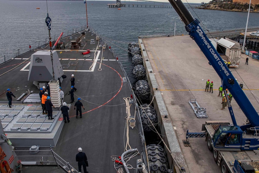 Sailors work on the deck of a ship.