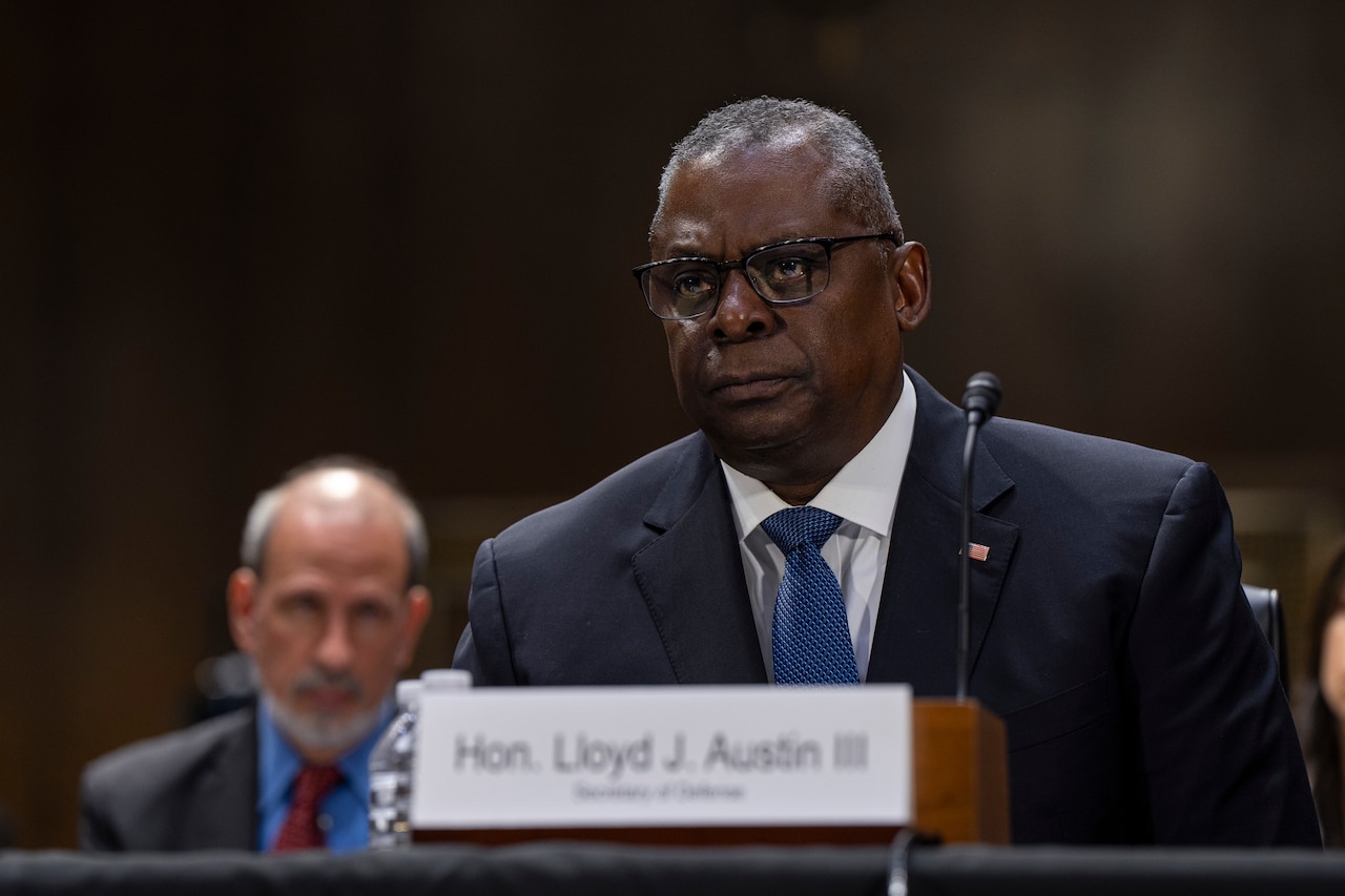 Secretary of Defense Lloyd J. Austin III speaks from behind a table.