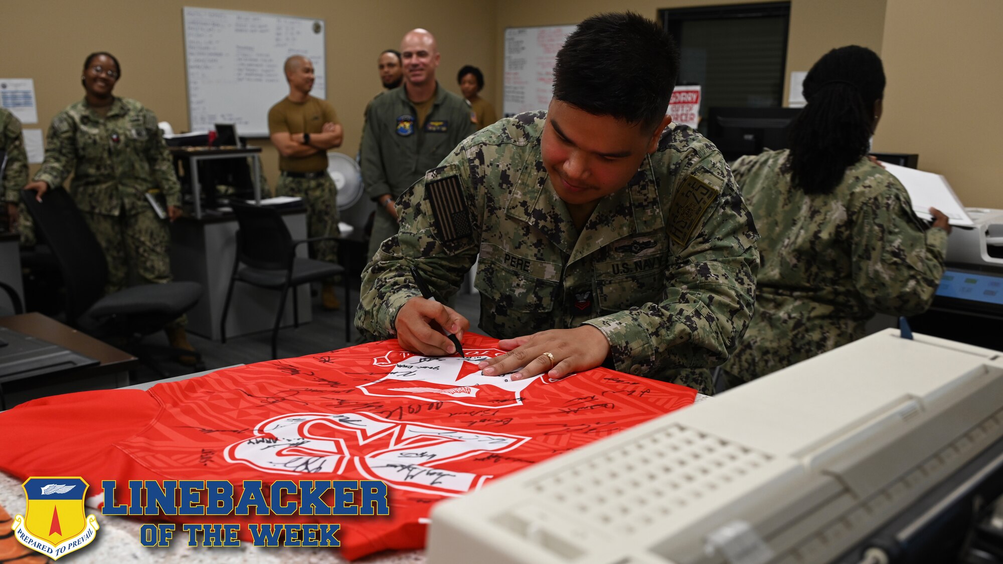 A Sailor signs a jersey.