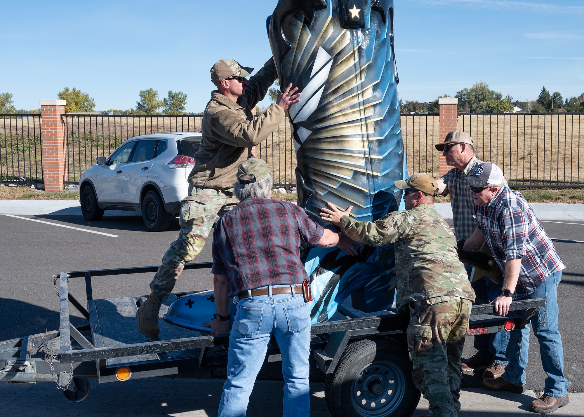 90 CES members unload a decorative boot from a truck