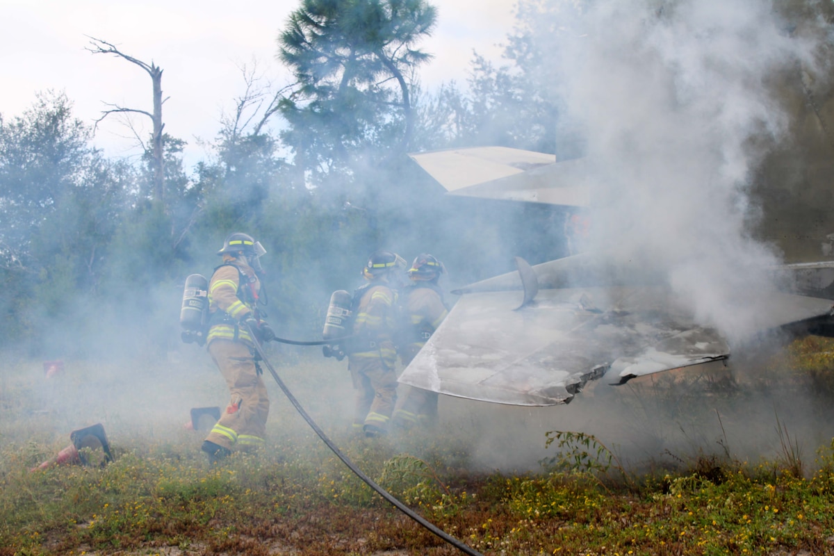 Firefighters from the Royal Canadian Armed Forces join the 801st Red Horse squadron for a hand line operation exercise