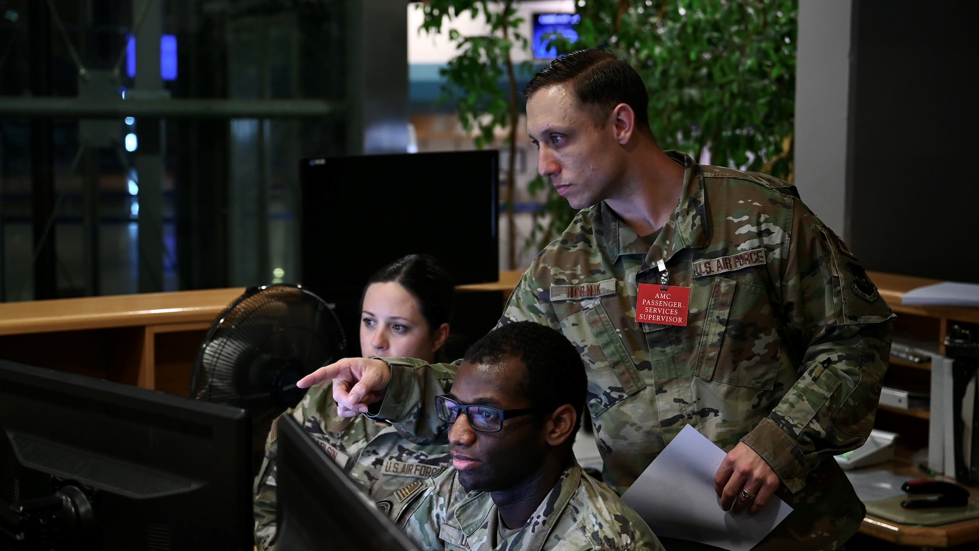 Staff Sgt. Stephen Hornik, a passenger services supervisor assigned to the 721st Aerial Port Squadron, directs his Airmen at the passenger terminal on Ramstein Air Base, Germany, Oct. 25, 2023.