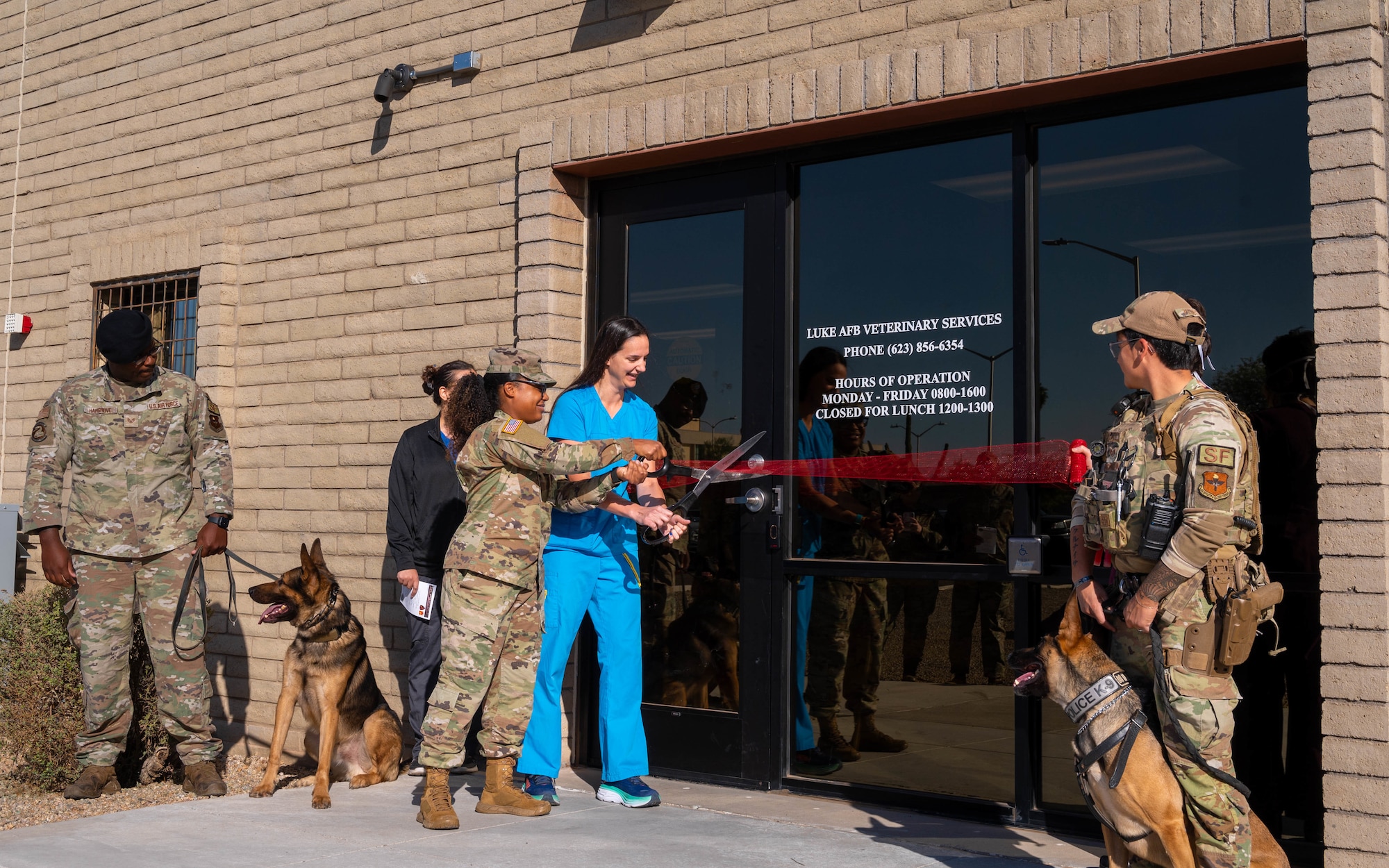 U.S. Army Sgt. Ambria Crooks (holding scissors), Luke AFB Veterinary Treatment Facility noncommissioned officer in charge, and Dr. Rachel Hallman, Luke AFB Veterinary Treatment Facility veterinary medical officer, cut a ribbon, Oct. 23, 2023, at Luke Air Force Base, Arizona.