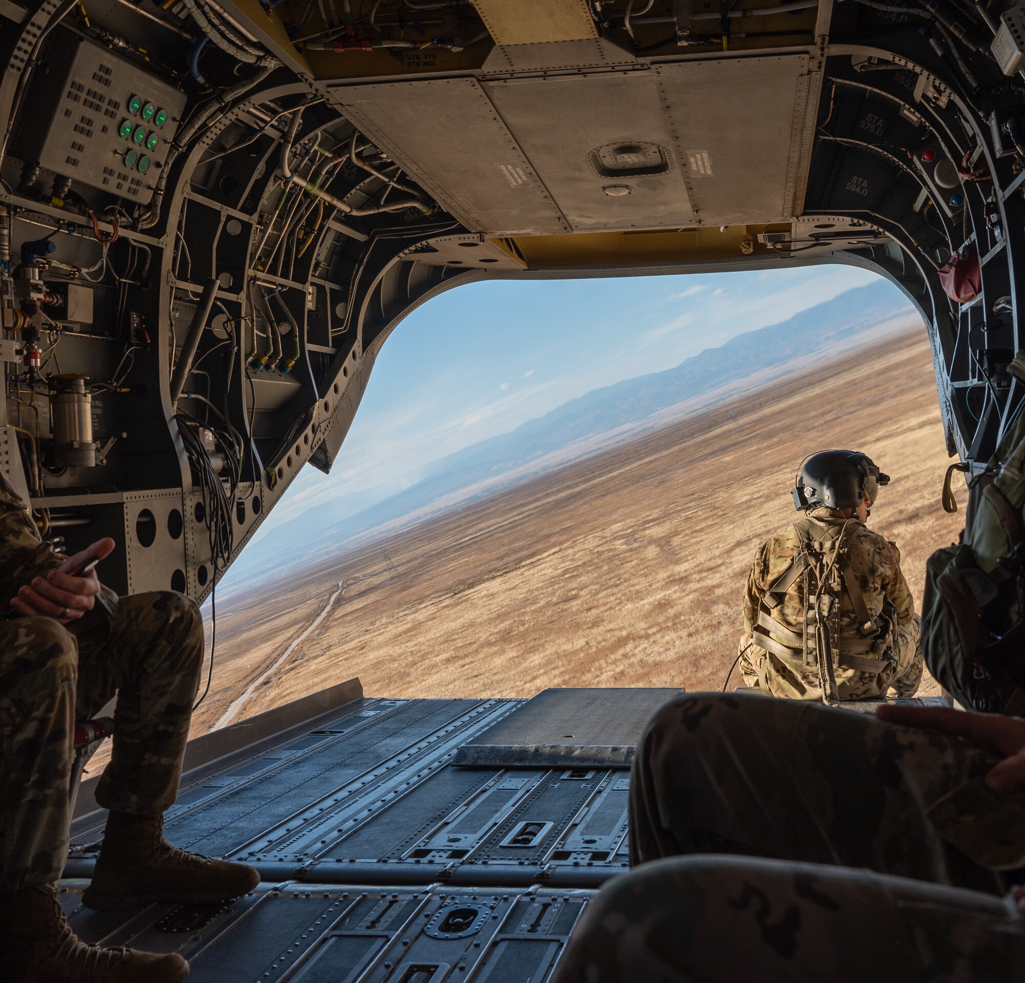 U.S. Army Soldier watches out of the back of a CH-47 Chinook flying over Fort Carson, Colorado.