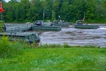 A bridge erection boat operated by Soldiers from the 250th Engineer Company (Multi-Role Bridge Company), 192nd Engineer Battalion, Connecticut Army National Guard, pulls away from a section of an improved ribbon bridge at Fort Drum, New York, Aug. 10, 2023.