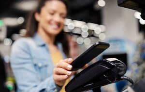 Woman using mobile wallet feature to pay.