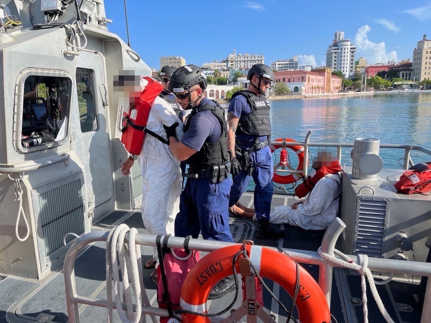 Coast Guard Station San Juan crewmembers transfer custody of three apprehended smugglers to federal law enforcement agents in San Juan, Puerto Rico, Aug. 31, 2023.  The apprehension resulted from the interdiction of a drug smuggling go-fast vessel carried out by the Coast Guard Cutter Heriberto Hernandez in Caribbean Sea waters southeast of Yabucoa, Puerto Rico, Aug. 26, 2023.  Additionally, 1,709 pounds of cocaine were seized in this case. (U.S. Coast Guard photo by Ricardo Castrodad)