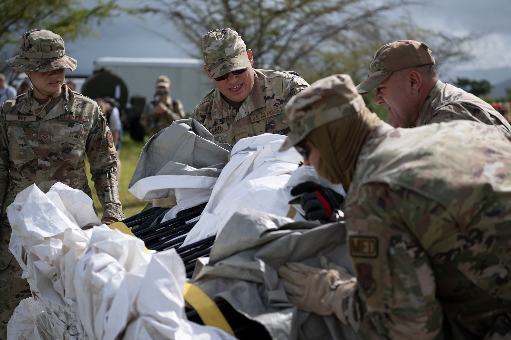U.S. Airmen assigned to the 156th Medical Group, Detachment 1, unpack a tent during a collective training exercise at Camp Santiago Joint Training Center, Salinas, Puerto Rico, Aug. 10, 2023. The exercise allowed service members assigned to the 156th Medical Group, 123rd Medical Group and the Puerto Rico Army National Guard to exchange knowledge and implement the National Guard CBRN Response Enterprise Information Management System, which assists with accelerating data collection from search and extraction teams in emergency events. (U.S. Air National Guard photo by Master Sgt. Rafael D. Rosa)