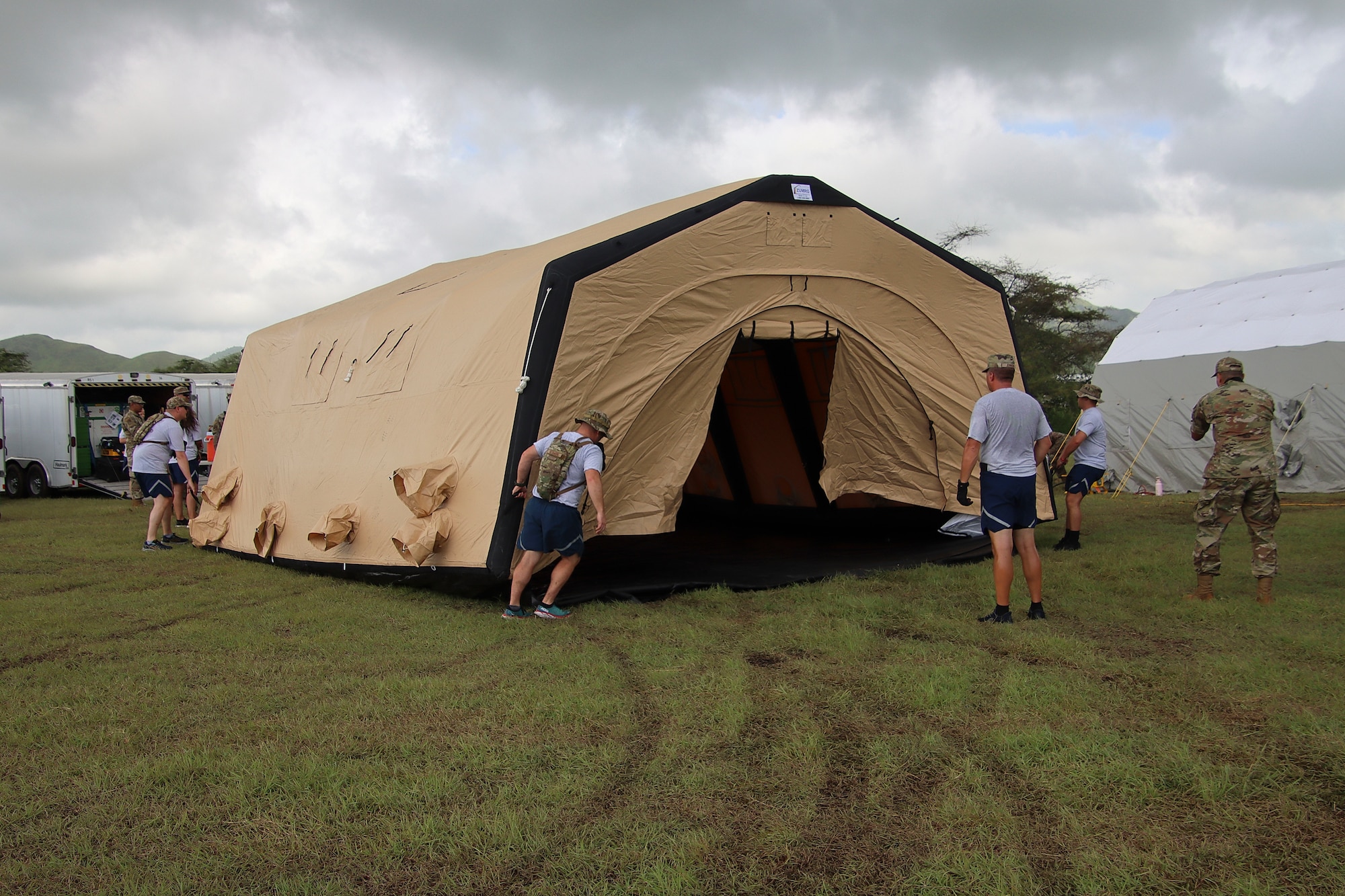 U.S. Airmen assigned to the 123rd Medical Group, Detachment 1, assemble an inflatable tent during a collective training exercise at Camp Santiago Joint Training Center, Salinas, Puerto Rico, Aug. 10, 2023. The exercise allowed service members assigned to the 156th Medical Group, 123rd Medical Group and the Puerto Rico Army National Guard to exchange knowledge and implement the National Guard CBRN Response Enterprise Information Management System, which assists with accelerating data collection from search and extraction teams in emergency events. (U.S. Air National Guard courtesy photo by Lt. Col. Geoffrey S Ball)