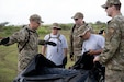 U.S. Airmen assigned to the 123rd Medical Group, Detachment 1, lay out an inflatable tent during a collective training exercise at Camp Santiago Joint Training Center, Salinas, Puerto Rico, Aug. 10, 2023. The exercise allowed service members assigned to the 156th Medical Group, 123rd Medical Group and the Puerto Rico Army National Guard to exchange knowledge and implement the National Guard CBRN Response Enterprise Information Management System, which assists with accelerating data collection from search and extraction teams in emergency events. (U.S. Air National Guard photo by Master Sgt. Rafael D. Rosa)