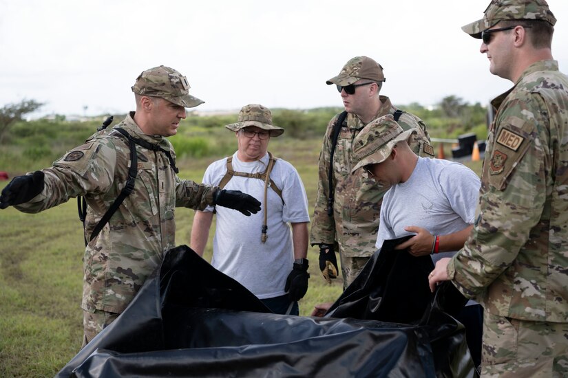 U.S. Airmen assigned to the 123rd Medical Group, Detachment 1, lay out an inflatable tent during a collective training exercise at Camp Santiago Joint Training Center, Salinas, Puerto Rico, Aug. 10, 2023. The exercise allowed service members assigned to the 156th Medical Group, 123rd Medical Group and the Puerto Rico Army National Guard to exchange knowledge and implement the National Guard CBRN Response Enterprise Information Management System, which assists with accelerating data collection from search and extraction teams in emergency events. (U.S. Air National Guard photo by Master Sgt. Rafael D. Rosa)