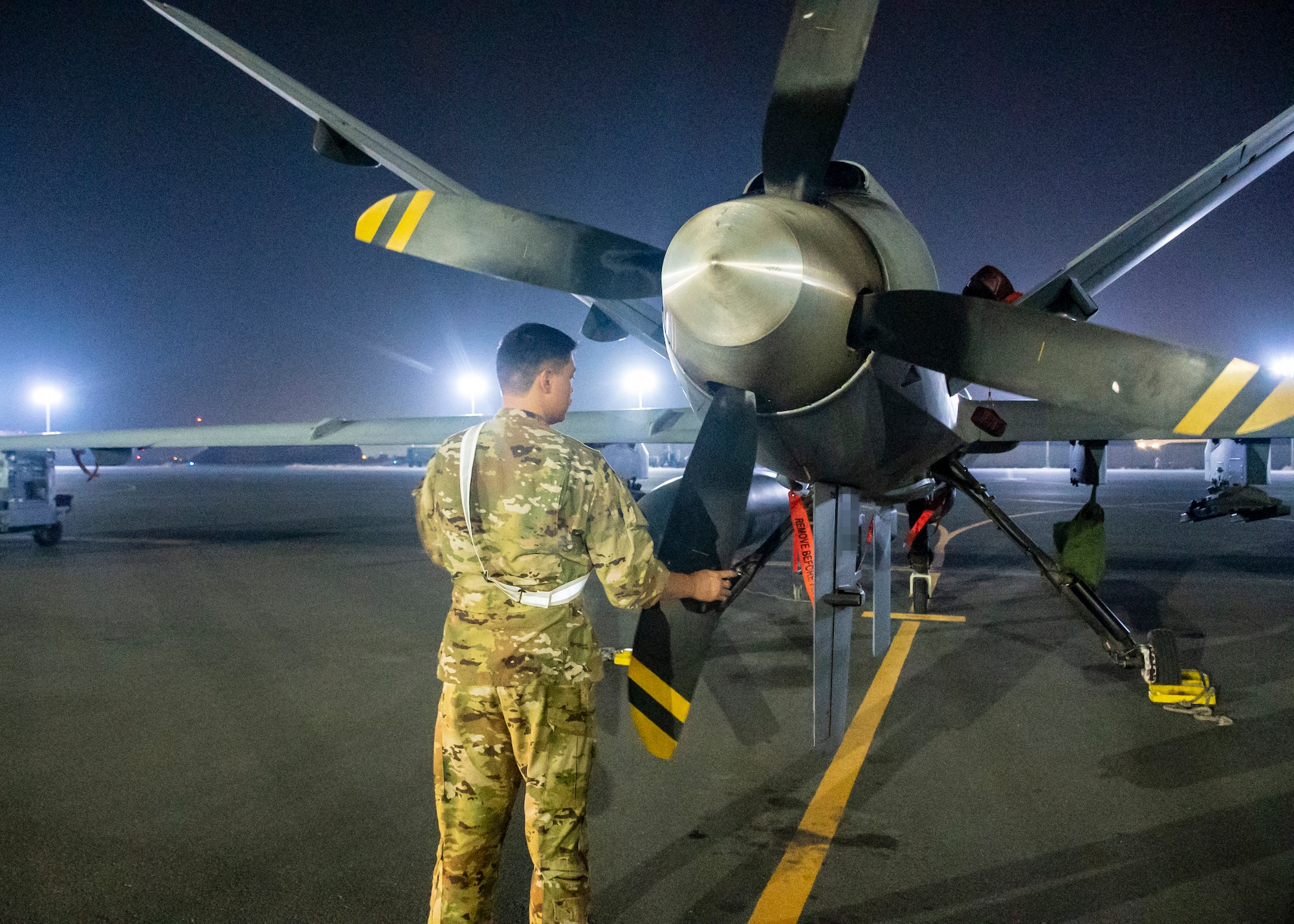 A U.S. Air Force service member assigned to the 46th Expeditionary Attack Squadron, conducts pre-flight checks on an MQ-9 aircraft in preparation for an Operation Agile Spartan mission departing from Ali Al Salem Air Base, Kuwait, August 21, 2023.