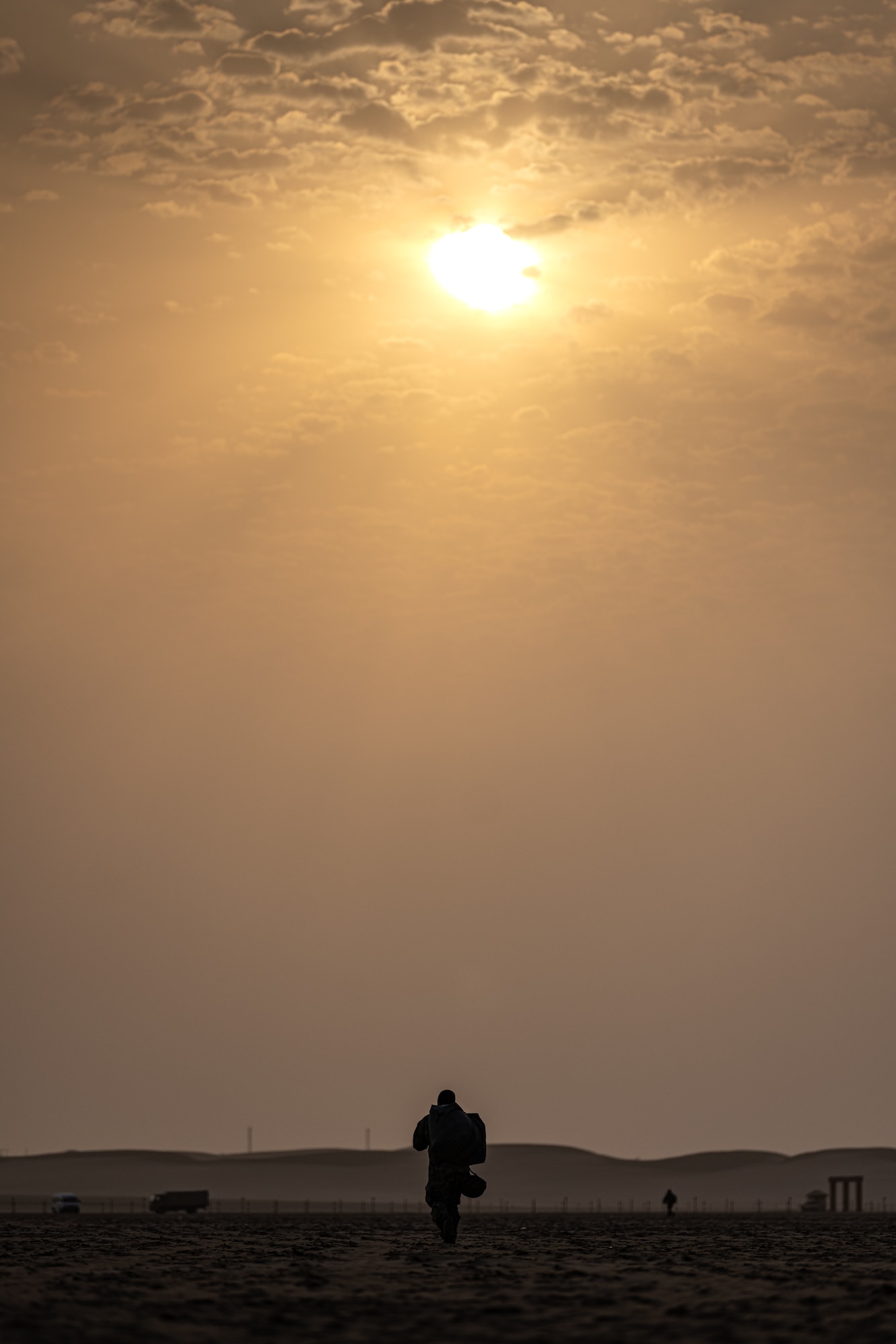 Person walking toward the sun in a desert
