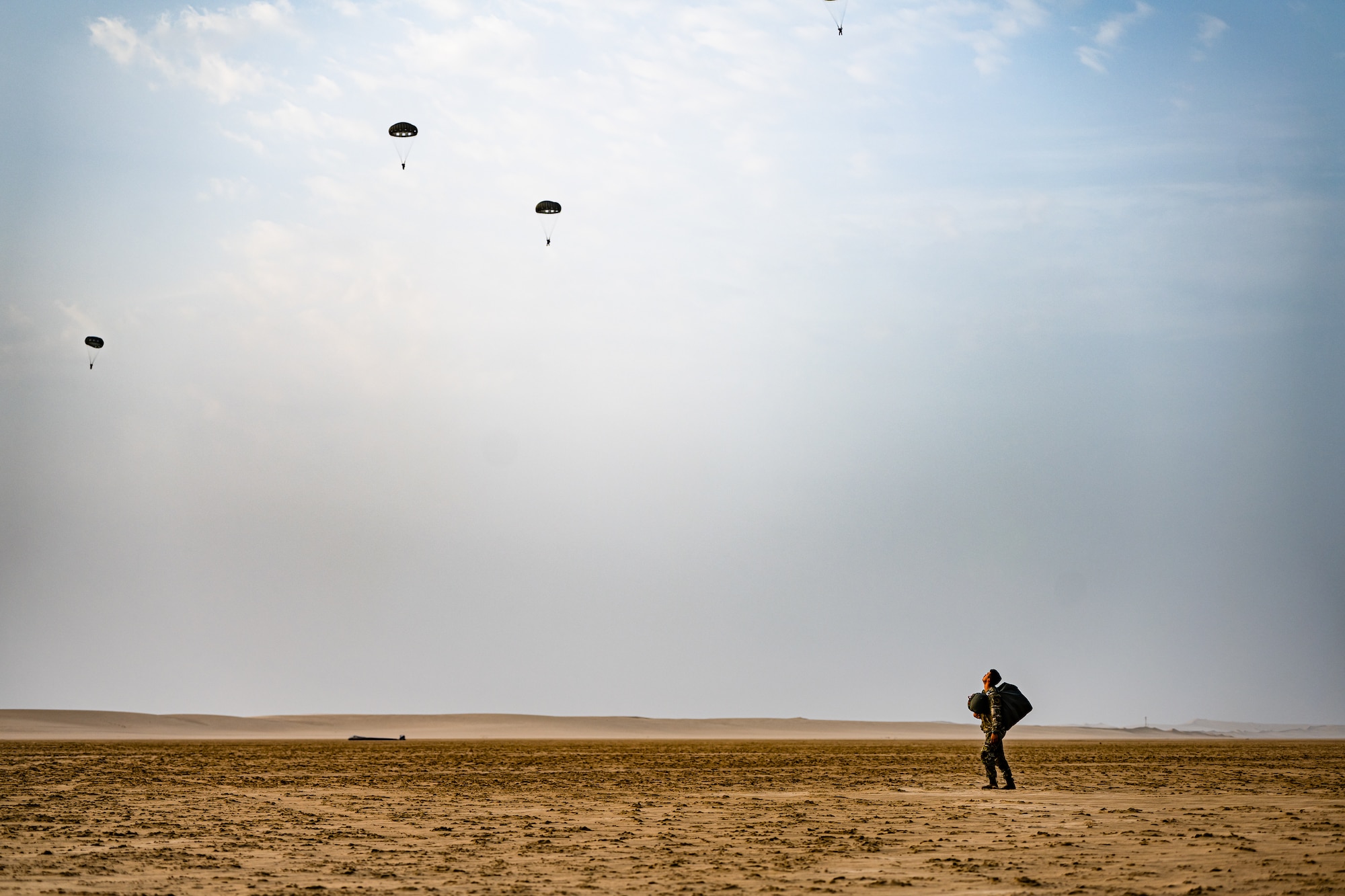 Paratroopers descending above the desert