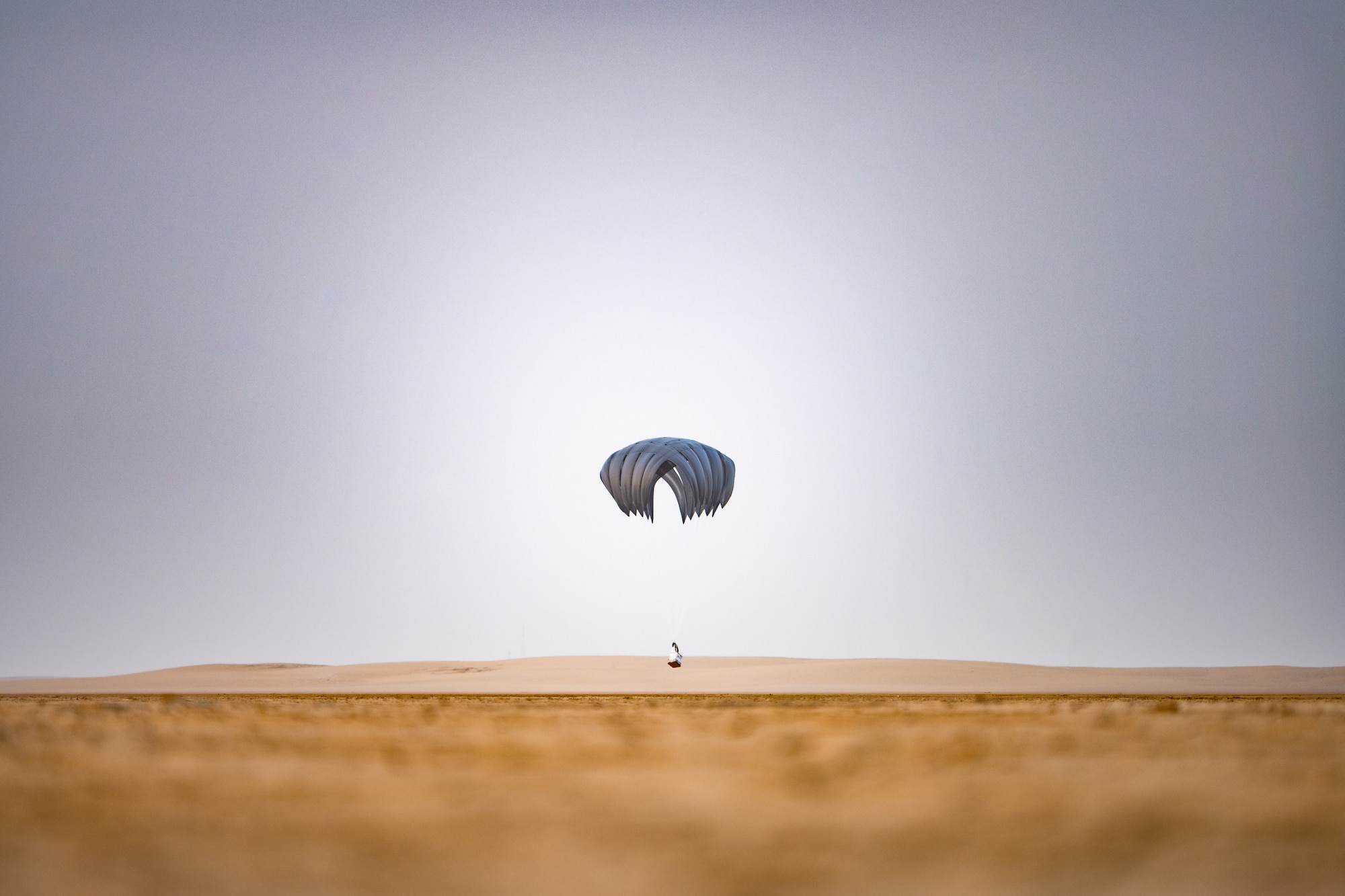 Cargo descending to the desert with a parachute