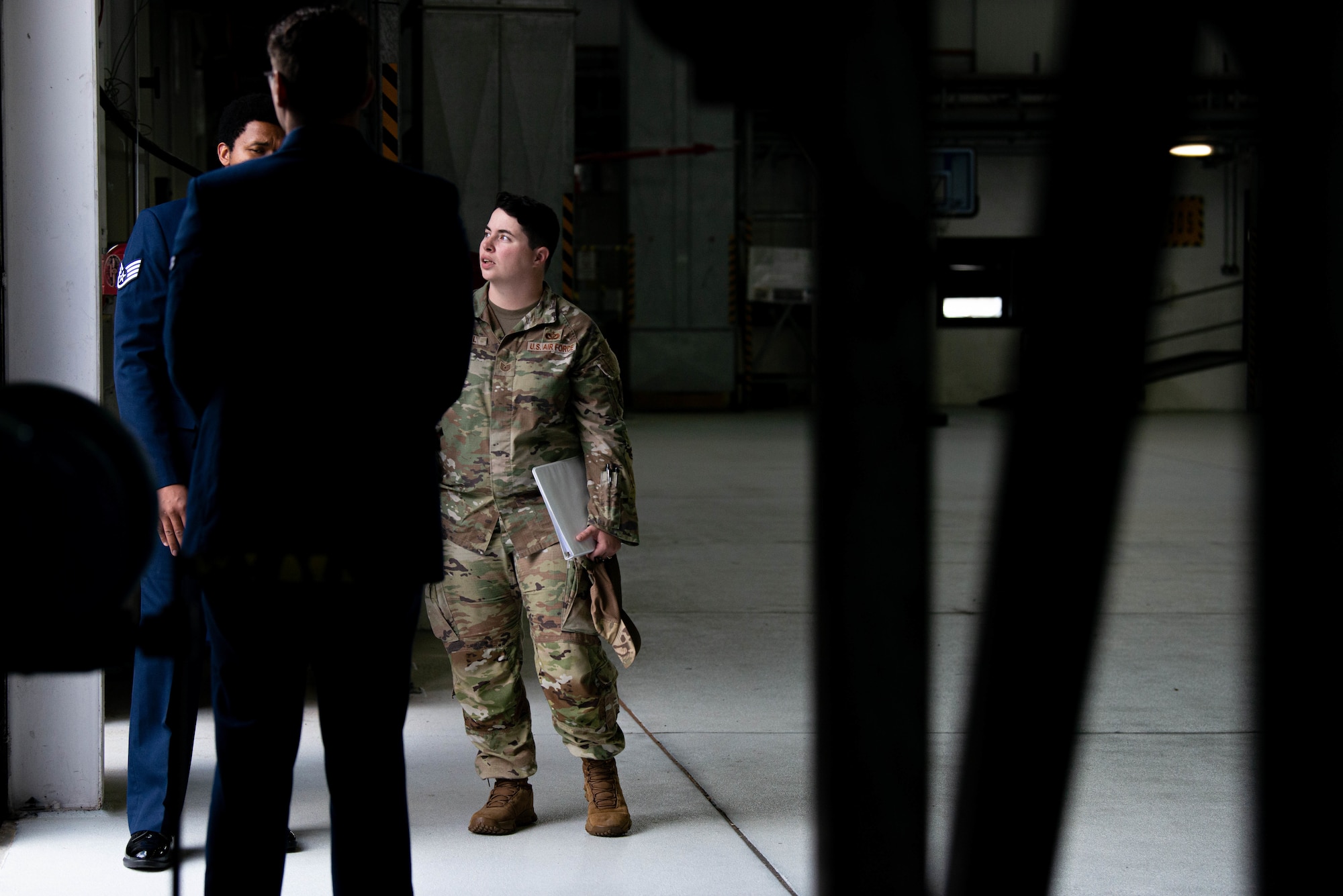 Tech. Sgt. Savanna Hudnall speaks with Airmen working at the entrance to a change of command ceremony