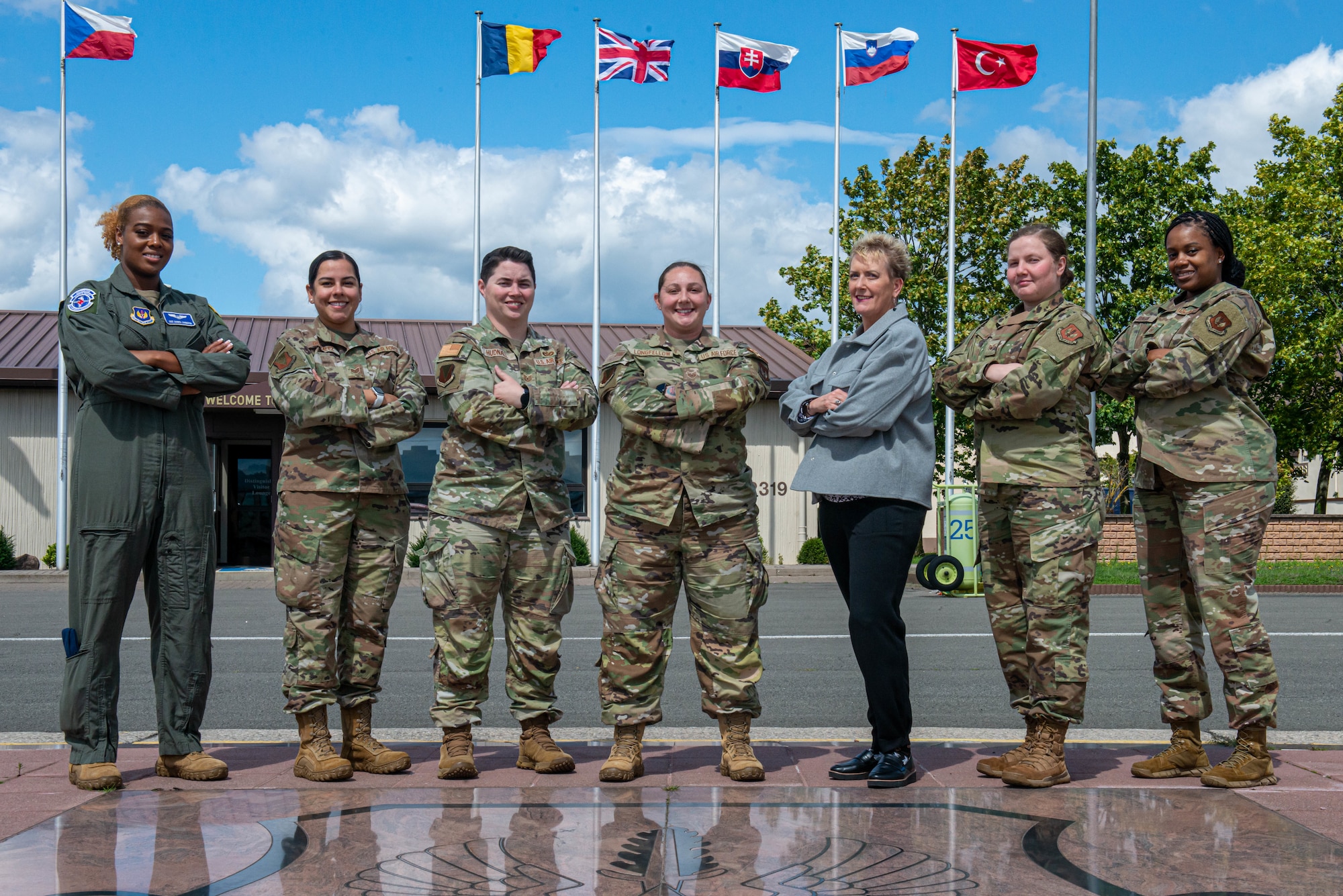 The 86th Airlift Wing protocol office stands together in front of the Ramstein Air Base distinguished visitor lounge
