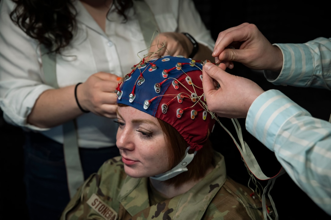 Wires are attached to an EEG cap on an airman's head.