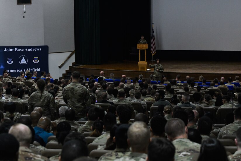 Military members meet in a theater.