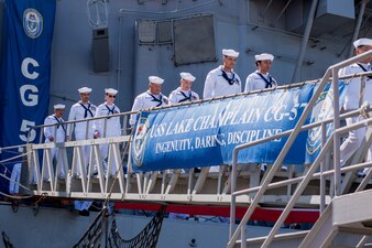The crew of USS Lake Champlain (CG 57) disembark the ship during a decommissioning ceremony at Naval Base San Diego.