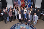 A group of people pose in a meeting room.