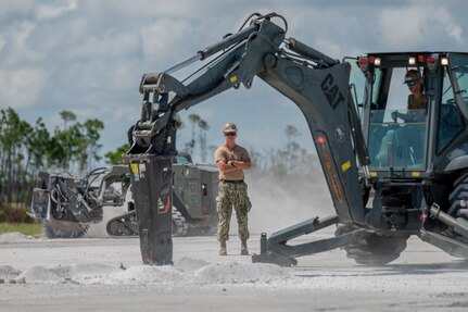 U.S. Navy Builder 3rd Class Tobin Long, assigned to Naval Mobile Construction Battalion 11 observes rapid airfield damage repair during a pre-deployment qualification exercise at the Silver Flag exercise site, Tyndall Air Force Base, Florida, Aug. 7, 2023. The Silver Flag exercise site is outfitted with a 1.2-thousand-acre training platform including a mock runway for RADR exercises. (U.S. Air Force photo by Senior Airman Tiffany Del Oso)