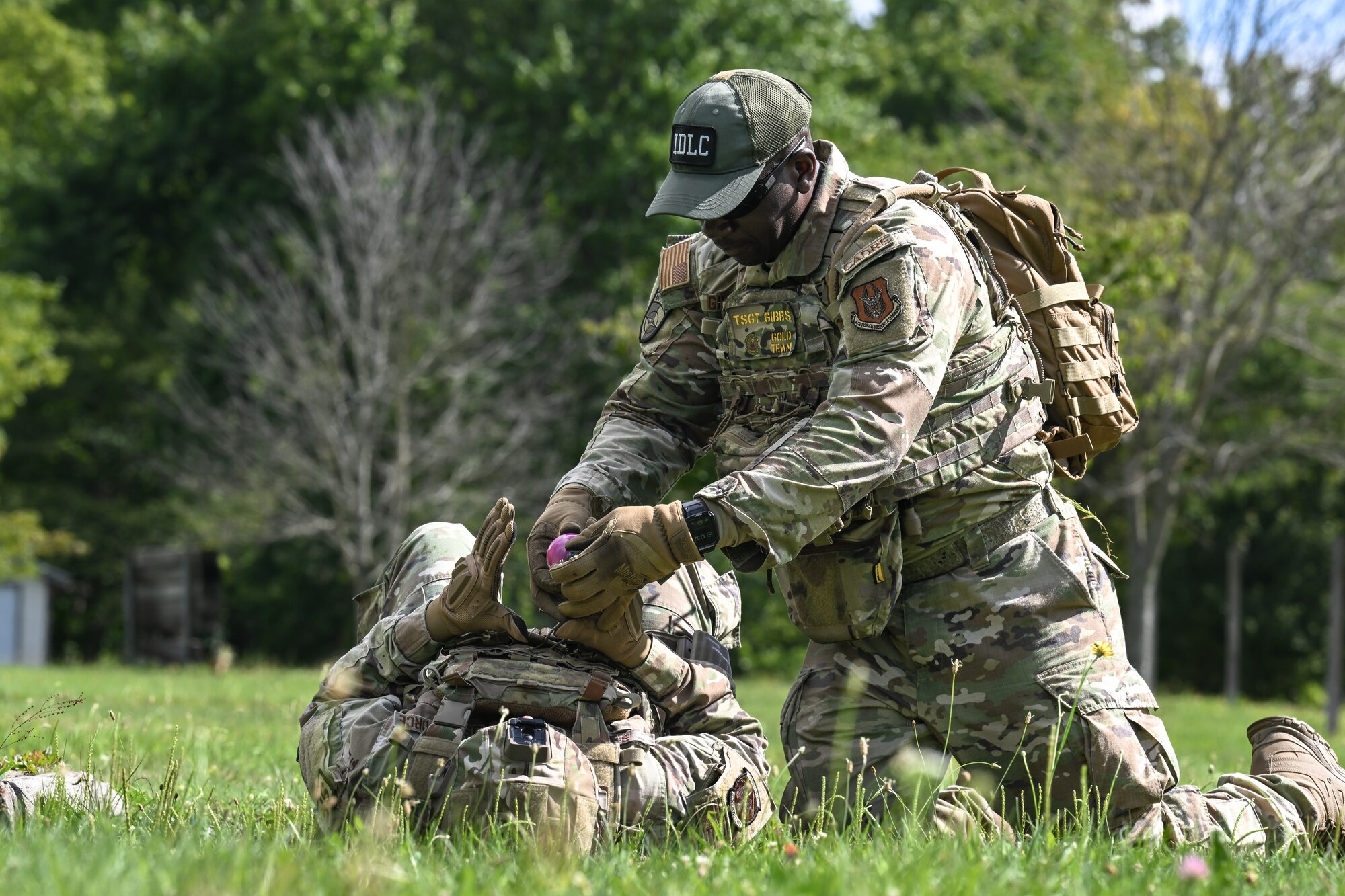 Staff Sgt. Arin Brown, a Defender assigned to the 919th Security Forces Squadron, Duke Field, Florida, receives a practice grenade from Tech. Sgt. Darnnelle Gibbs, an Integrated Defense Leadership Course cadre member assigned to the 514th SFS, Joint Base McGuire-Dix-Lakehurst, New Jersey, during IDLC’s grenade training on Aug. 15, 2023, at Camp James A. Garfield Joint Military Training Center, Ohio.