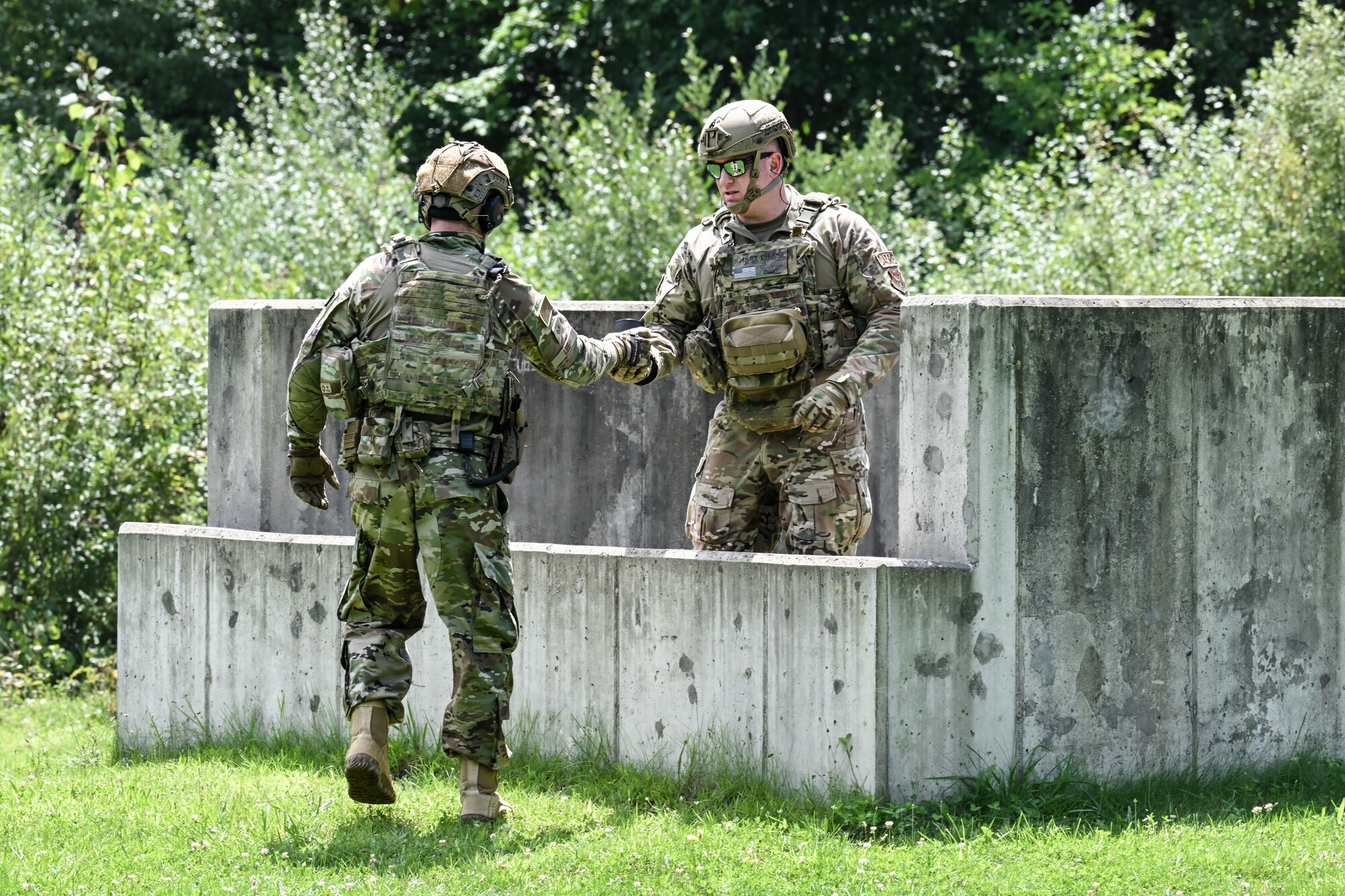Staff Sgt. Samuel Lee, a Defender assigned to the Texas Air National Guard’s 204th Security Forces Squadron, hands a grenade ready for detonation to Senior Master Sgt. Daniel Chase, Integrated Defense Leadership Course chief assigned to the 310th SFS, Schriever Space Force Base, Colorado, on Aug. 15, 2023, at Camp James A. Garfield Joint Military Training Center, Ohio.